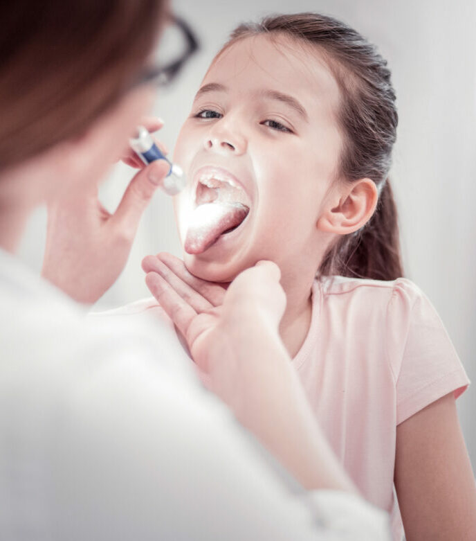 Ärztin untersucht Mund eines Kindes